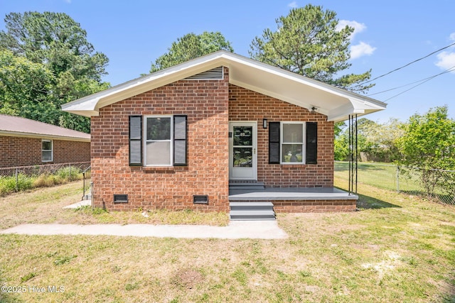 811 Crawford St, Goldsboro, NC 27530 - bungalow with fence, a front yard, brick siding, and crawl space
