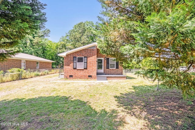811 Crawford St, Goldsboro, NC 27530 - rear view of property featuring brick siding, a fenced backyard, a yard, and crawl space