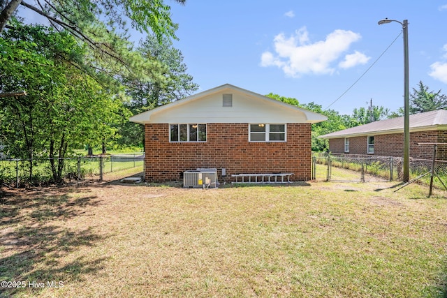 811 Crawford St, Goldsboro, NC 27530 - rear view of property with brick siding, a fenced backyard, a gate, central AC unit, and a yard