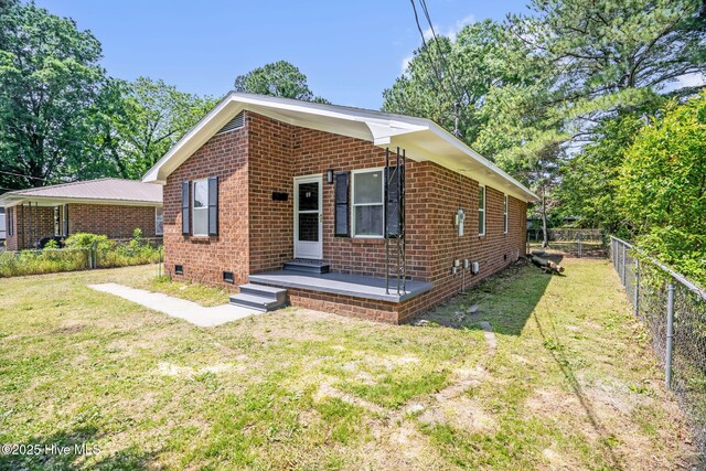811 Crawford St, Goldsboro, NC 27530 - view of front facade with brick siding, crawl space, fence, and a front yard