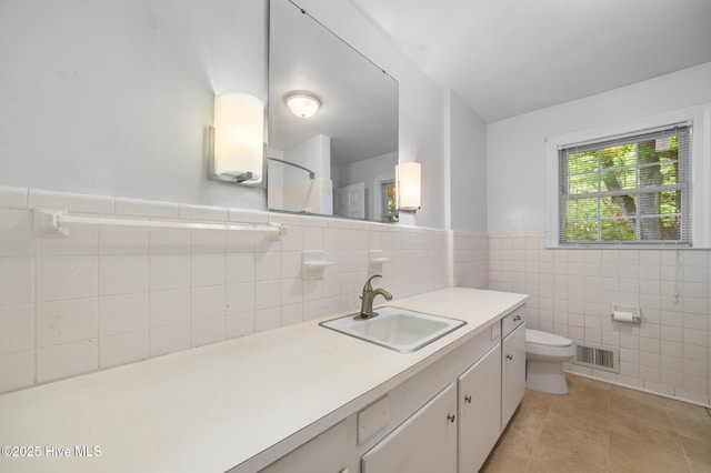 bathroom with visible vents, tile patterned flooring, a shower, toilet, and tile walls