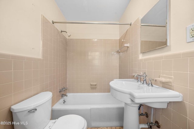 full bath with tile walls, shower / bathing tub combination, and toilet