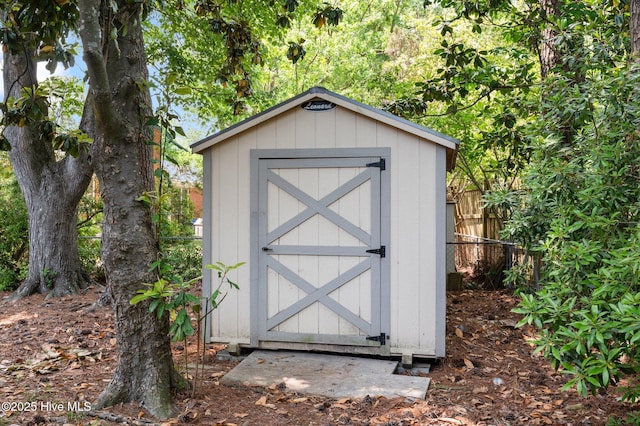 view of shed featuring fence