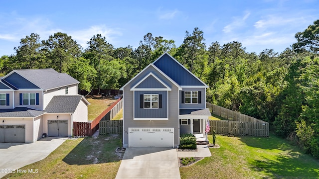 view of front facade featuring fence, driveway, a front yard, and a garage