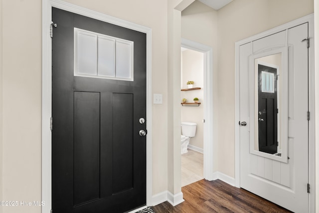 entrance foyer featuring baseboards and dark wood finished floors