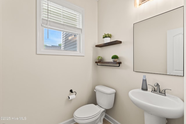 bathroom with a sink, baseboards, and toilet
