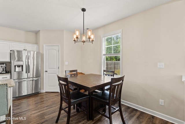 dining space with baseboards, dark wood finished floors, and an inviting chandelier