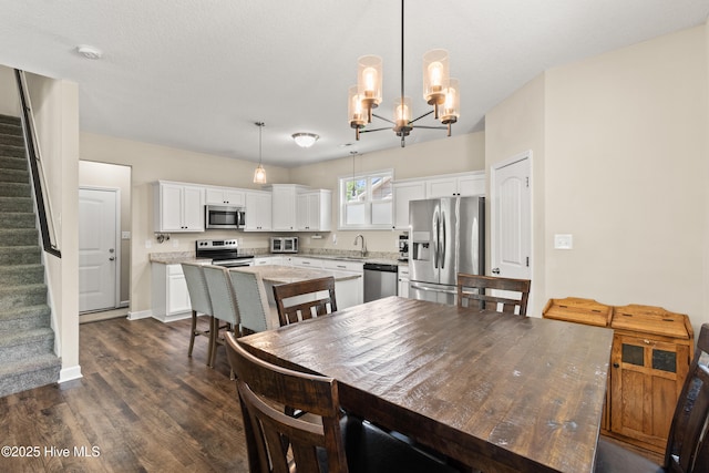 dining area with a chandelier, baseboards, dark wood finished floors, and stairway