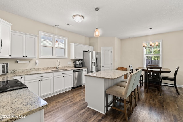 kitchen featuring an inviting chandelier, visible vents, dark wood-style flooring, a sink, and stainless steel appliances