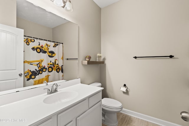 full bath with vanity, curtained shower, wood finished floors, toilet, and baseboards