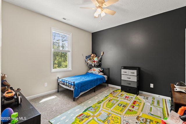carpeted bedroom with baseboards, visible vents, and ceiling fan