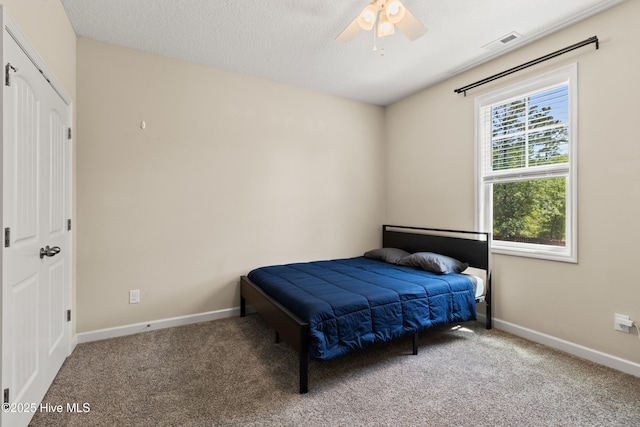 carpeted bedroom featuring visible vents, a ceiling fan, and baseboards