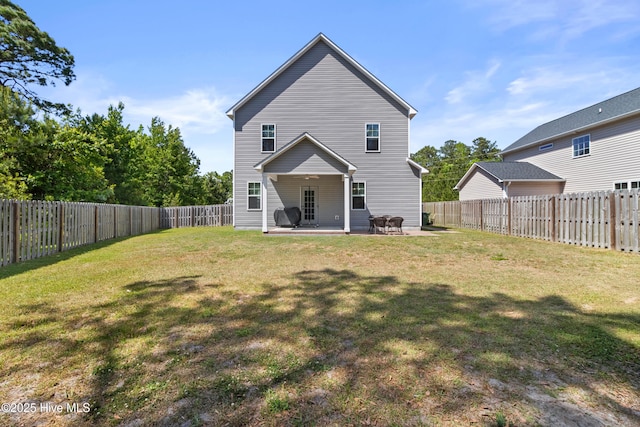 rear view of property with a fenced backyard, a patio, and a lawn