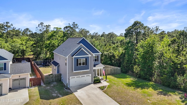 view of front of house with a garage, a front lawn, fence, concrete driveway, and a view of trees