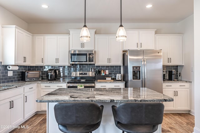 kitchen featuring recessed lighting, light wood finished floors, appliances with stainless steel finishes, and white cabinets