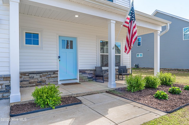 property entrance with a porch and stone siding