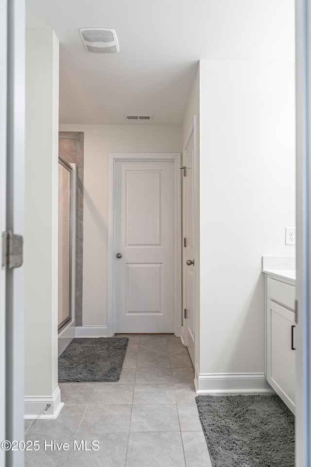 full bathroom with baseboards, visible vents, and a shower stall