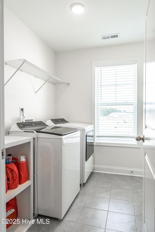 washroom featuring plenty of natural light, laundry area, independent washer and dryer, baseboards, and light tile patterned flooring