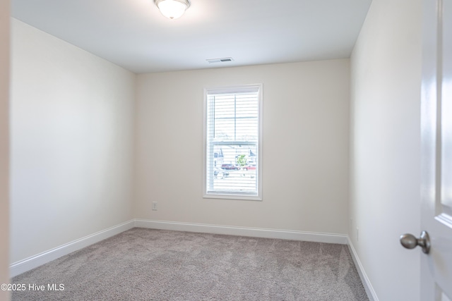 unfurnished room featuring baseboards, visible vents, and carpet