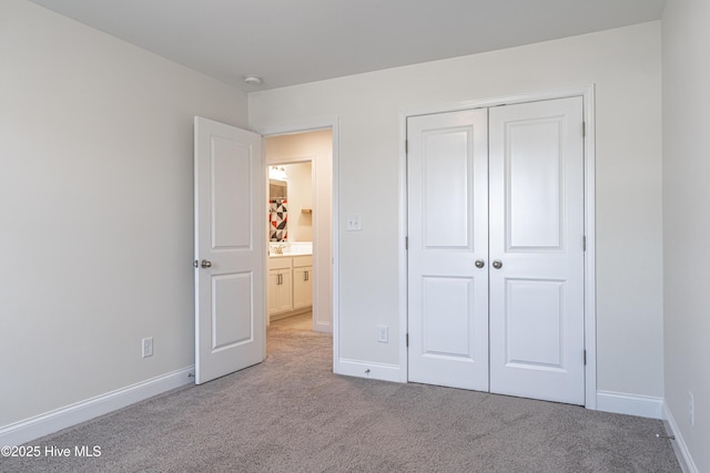 unfurnished bedroom with carpet floors, baseboards, and a closet