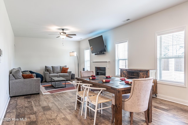 dining space with visible vents, baseboards, ceiling fan, and wood finished floors