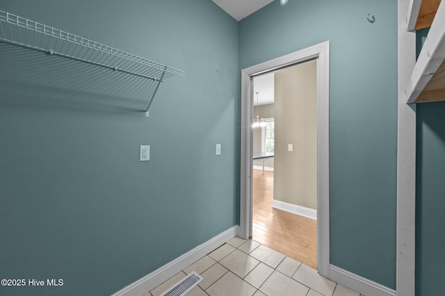 laundry room featuring light tile patterned floors, baseboards, and visible vents