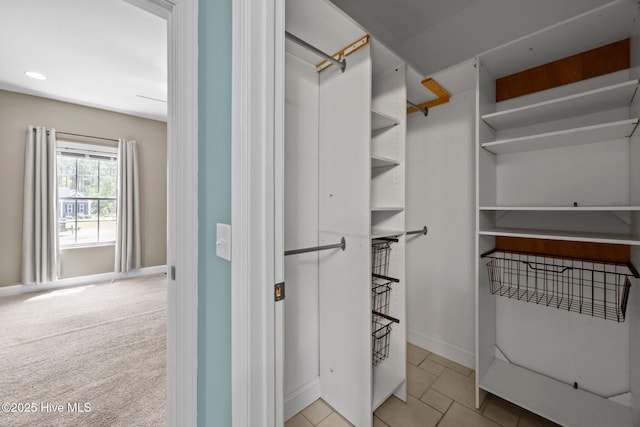 walk in closet featuring tile patterned flooring and carpet flooring
