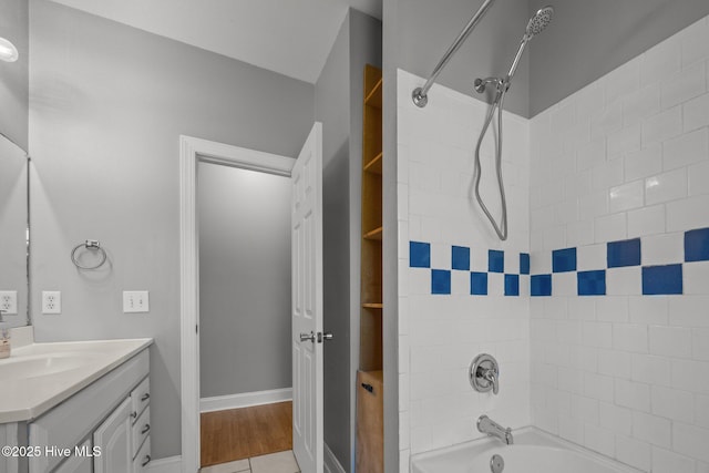 bathroom with shower / bathtub combination, baseboards, and vanity