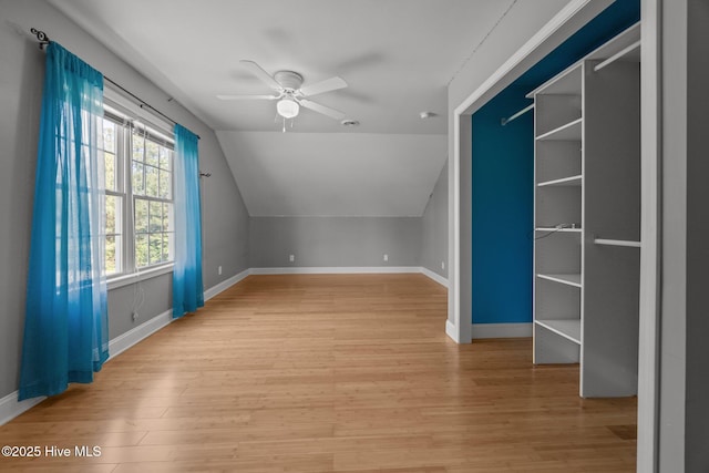 additional living space featuring a ceiling fan, baseboards, lofted ceiling, and light wood finished floors