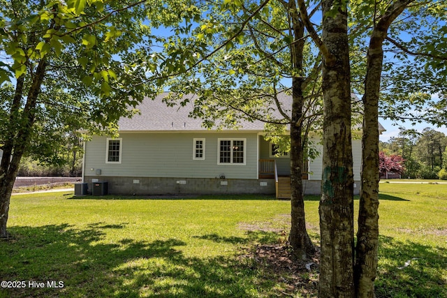 back of property with a shingled roof, a yard, central AC, and crawl space