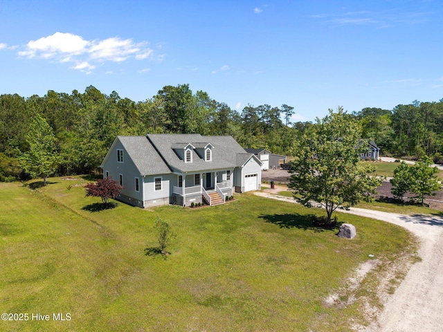 view of front of home with a garage, dirt driveway, a porch, and a front lawn
