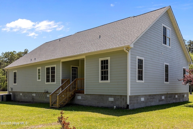 back of house with a yard, crawl space, cooling unit, and roof with shingles