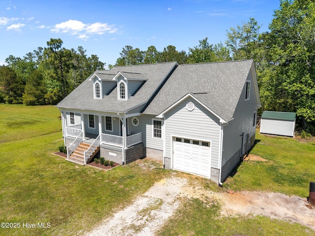 cape cod home featuring a front lawn, covered porch, a shingled roof, an attached garage, and driveway