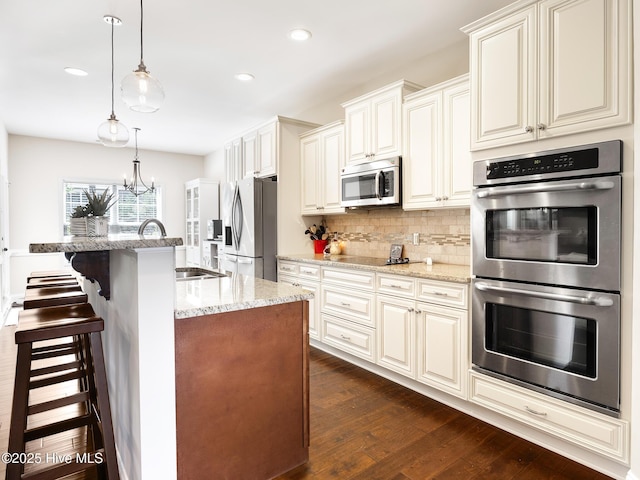 114 Schever Rd, West End, NC 27376 - kitchen featuring dark wood-style flooring, a sink, a kitchen breakfast bar, stainless steel appliances, and tasteful backsplash