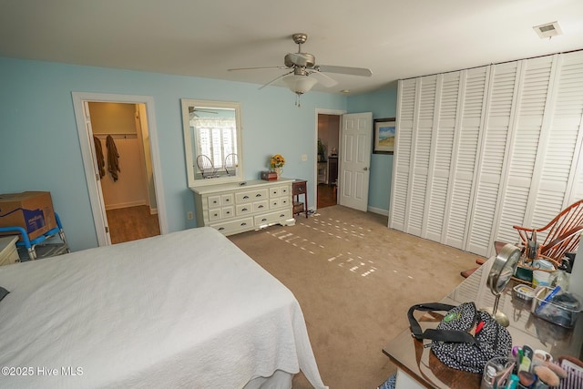 carpeted bedroom featuring a ceiling fan, visible vents, and a closet