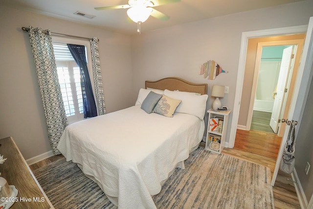 bedroom featuring ceiling fan, baseboards, visible vents, and wood finished floors