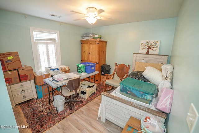 bedroom featuring ceiling fan, visible vents, and wood finished floors