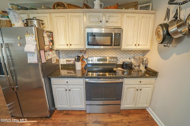 kitchen featuring appliances with stainless steel finishes, cream cabinets, and decorative backsplash