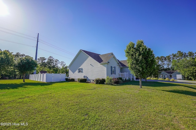 view of property exterior with a lawn and fence