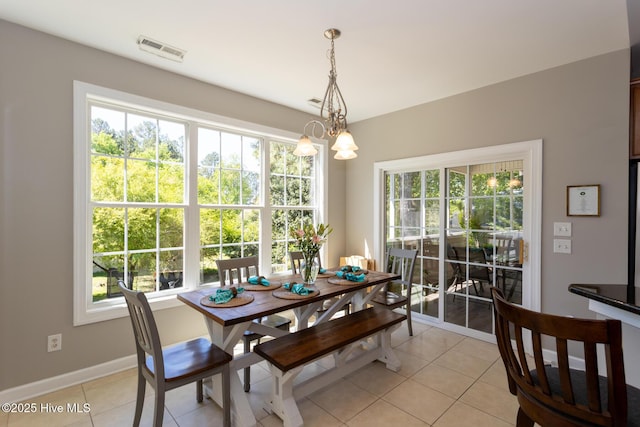dining space with visible vents, baseboards, a chandelier, and light tile patterned flooring