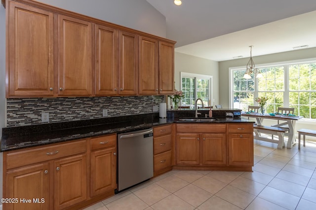 kitchen with stainless steel dishwasher, brown cabinetry, a peninsula, a sink, and backsplash