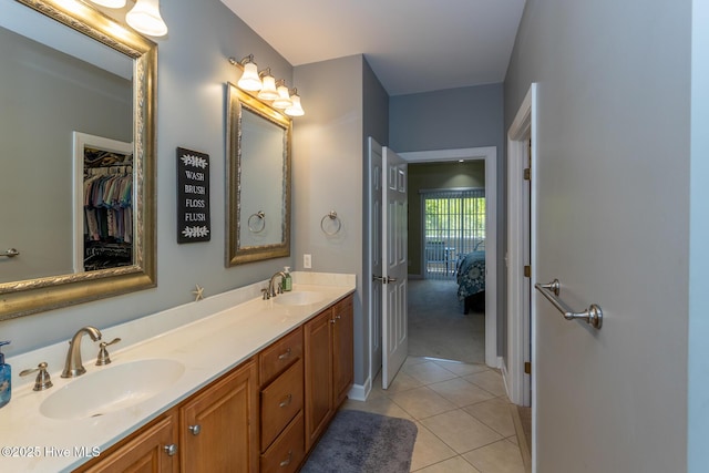 bathroom featuring a sink, tile patterned floors, ensuite bath, and double vanity