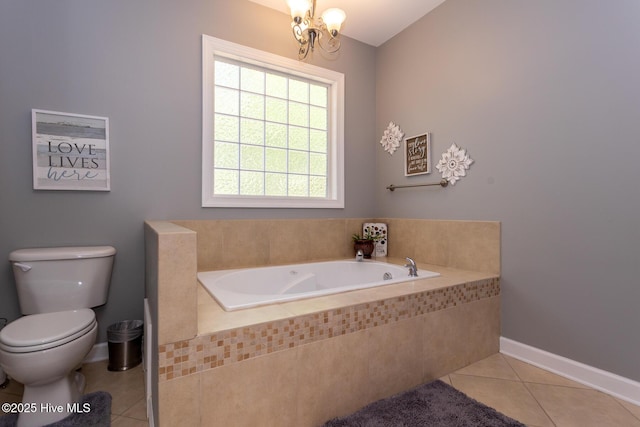 bathroom featuring a garden tub, tile patterned flooring, baseboards, toilet, and an inviting chandelier