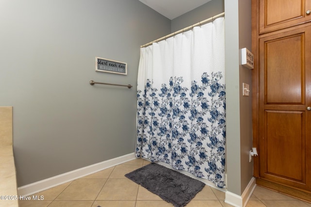 full bathroom featuring baseboards, curtained shower, and tile patterned flooring
