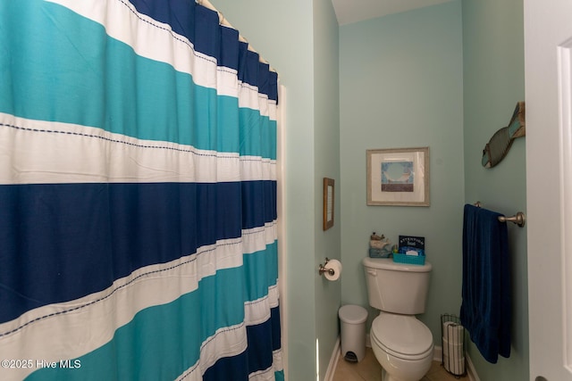 bathroom with tile patterned flooring, baseboards, toilet, and a shower with curtain
