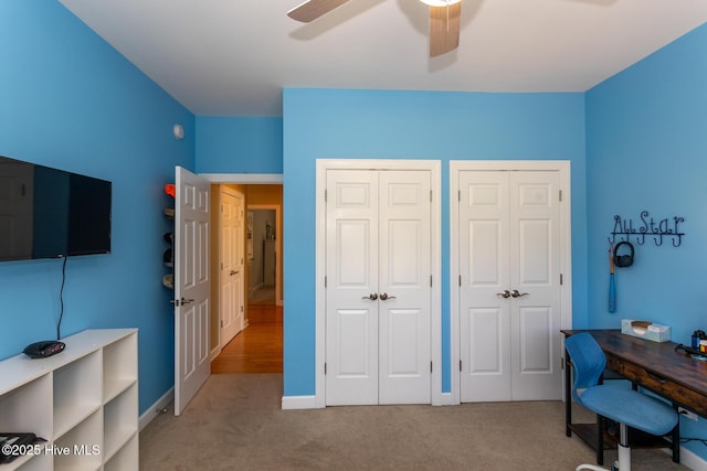 carpeted home office featuring ceiling fan