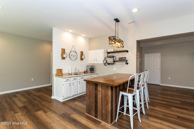 kitchen featuring visible vents, open shelves, baseboards, dark wood-style floors, and wood counters