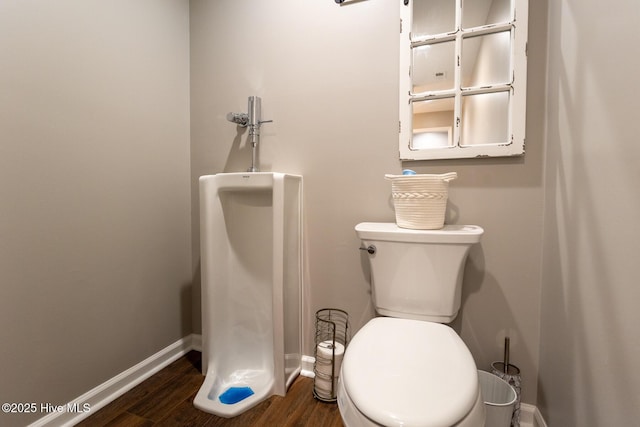 bathroom featuring baseboards, wood finished floors, and toilet