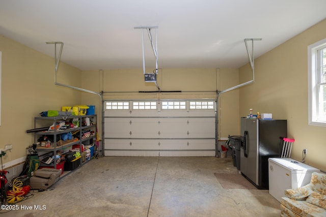 garage featuring stainless steel fridge with ice dispenser, a garage door opener, and refrigerator