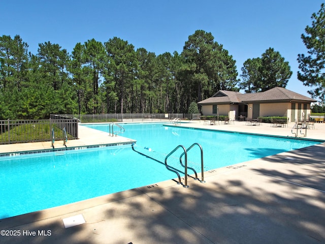 community pool with a patio and fence